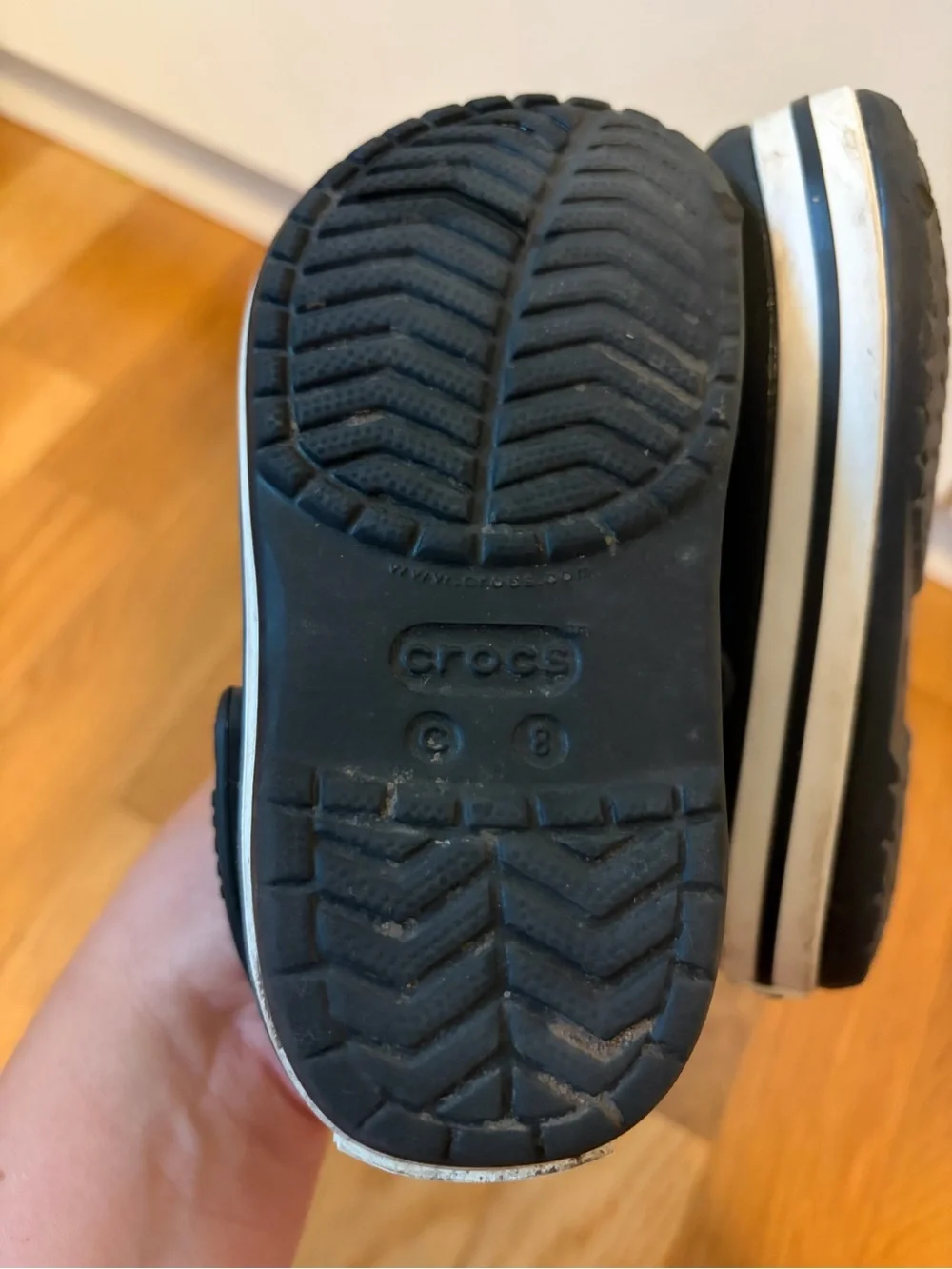 Kid’s black Croc slip on shoe with white band size 8